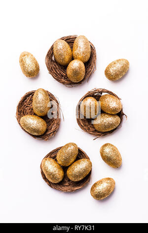 Golden glitter Eier in ein Nest. Ostern Hintergrund. Finanzen Konzept Stockfoto