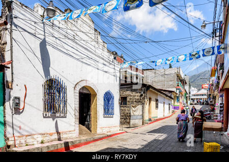 Santiago Atitlan See, Lake Atitlan, Guatemala - 8. März 2019: Maya Frauen vorbei an Kirche Renovierungen in lakeside Stadt im guatemaltekischen Hochland. Stockfoto