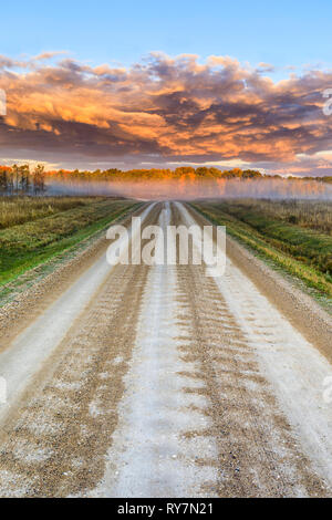 Ein Land, unbefestigte Straße, bei Sonnenaufgang, Manitoba, Kanada. Stockfoto