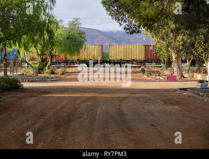 Zuges mit Containern am Bahnübergang auf der Piste, in der Großen Karoo, Südafrika Stockfoto