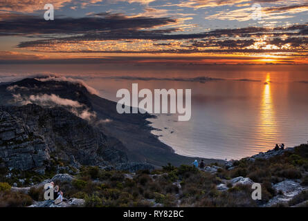 Paare beobachten Sie den Sonnenuntergang über der Zwölf Apostel und den Atlantischen Ozean vom Tafelberg, Kapstadt, Western Cape, Südafrika