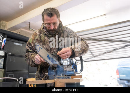 Forstwirtschaft Skills: Menschen, die in einem eintägigen Workshop in, wie man die Schneiden auf die Links einer Kettensäge schärfen, und für die Betreuung sicher und die Power Tool verwenden. Wales UK Stockfoto