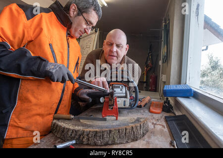 Forstwirtschaft Skills: Menschen, die in einem eintägigen Workshop in, wie man die Schneiden auf die Links einer Kettensäge schärfen, und für die Betreuung sicher und die Power Tool verwenden. Wales UK Stockfoto