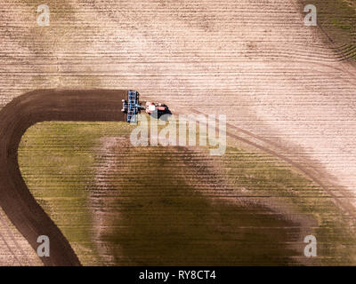 Luftaufnahme des Traktors im Feld, landwirtschaftlichen Bereich arbeiten. Traktor im Feld kultivieren, Luftbild. Stockfoto