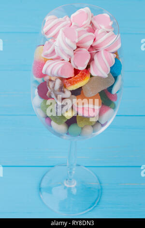 Becher Glas mit bunten Bonbons gefüllt. Stockfoto