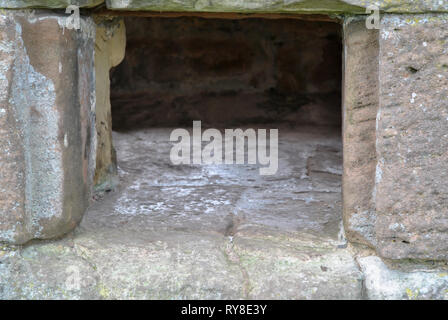 Ein rechteckiges Loch in einer alten Steinmauer Stockfoto