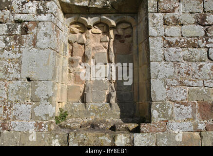 Ein alter Gemauerter, bogenförmige Fenster in eine Mauer aus Stein Stockfoto