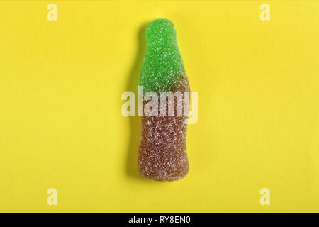 Flasche Cola candy auf gelbem Hintergrund Stockfoto