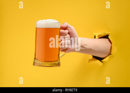 Hand hält ein Bierglas Stockfoto