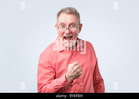 Reifer Mann schreien Ja und die geballte Faust in die Luft, Gefühl, aufgeregt. Stockfoto