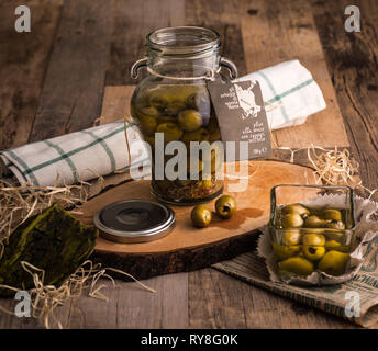 Flasche gießen natives Olivenöl in einer Schüssel hautnah Stockfoto