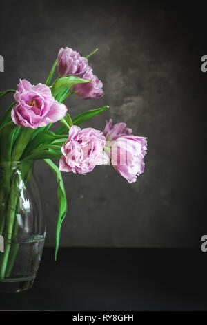 Rosa Tulpen in der Vase auf einem dunklen Hintergrund Stockfoto
