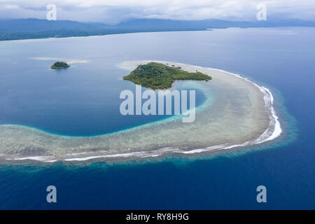 Eine wunderschöne, tropische Insel ist von Riff in Papua Neuguinea umgeben. In diesem abgelegenen Gebiet ist Teil der Korallen Dreieck aufgrund seiner biologischen Vielfalt der Meere. Stockfoto