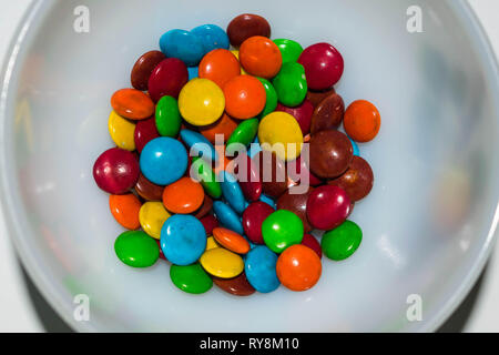 Bunte beschichtet Pralinen in einer Schüssel mit weißen bacground. Stockfoto