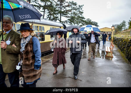 Menschen auf dem Weg zum Rennen in Cheltenham Cheltenham Racecourse auf der Gloucestershire Warwickshire Steam Railway von Toddington, wo ein besonderes Erbe Dampf Express Service ist die Rasse goers nach Cheltenham ankommen. Stockfoto