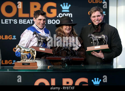 Jockey Harry Skelton (links) mit Trainer Dan Skelton (rechts) und ausgezeichnete Verbindungen nach Roksana gewinnt die OLBG Mares Hürde während Meister Tag der 2019 Cheltenham Festival in Cheltenham Racecourse. Stockfoto