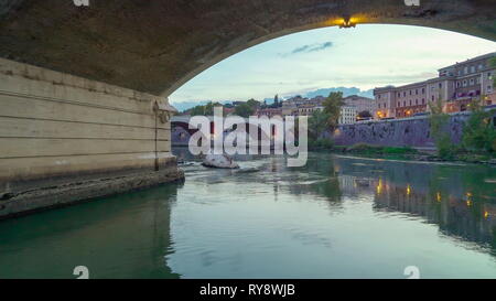 Fahrt entlang der sauberen Wasser des Tiber in Rom Italien unter der großen Brücke an einem Nachmittag gehen Stockfoto