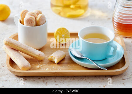 Schwamm finger Kekse serviert mit einer Tasse Tee auf Holz- Fach. Stockfoto