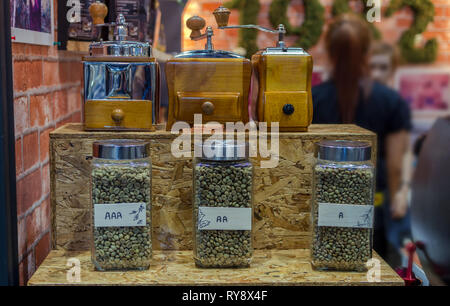 Rohkaffee in der Flasche im Regal mit traditionellen Kaffeebohnen und Schleifer Stockfoto
