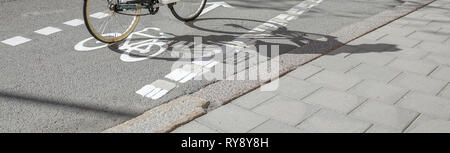 Ein Fahrrad auf einem Radweg. Weiß bike Symbol auf die Straße gemalt. Konzept für alltägliche Bewegungen, umweltfreundlich und tägliche Übung. Stockfoto