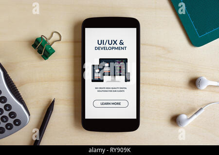 UI/UX-Entwurf und Entwicklung Konzept auf Smart Phone auf Holzschreibtisch. Alle Inhalte werden von mir gestaltet. Flach Stockfoto