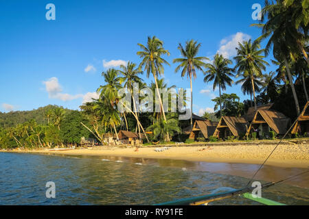 Exotische Cabanas am Strand und Palmen auf Port Barton, Palawan - Philippinen Stockfoto