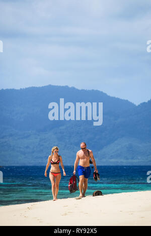 Europäische Ferienhäuser Paar in Badebekleidung, Wandern am White Sand Beach - Linapacan Insel Palawan - Philippinen Stockfoto