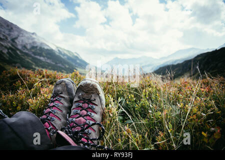 Schneiden Sie einer Frau in die Wanderstiefel Wer ist die idyllische Berglandschaft geniessen. Stockfoto
