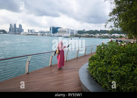 Solo muslimische Frau in Rosa hijab unter selfie am Harbourfront, Singapur Stockfoto