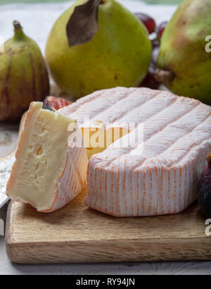 Rundes Stück französischer Käse Fleur Rouge aus Kuhmilch hergestellt als Dessert serviert mit frischen Feigen und Birnen Nahaufnahme Stockfoto