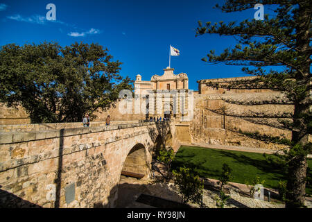 MDINA, MALTA - November, 2018 - Touristen überqueren Sie die Fußgängerbrücke zum Stadttor und Stadtzentrum, Mdina, Malta, Stockfoto