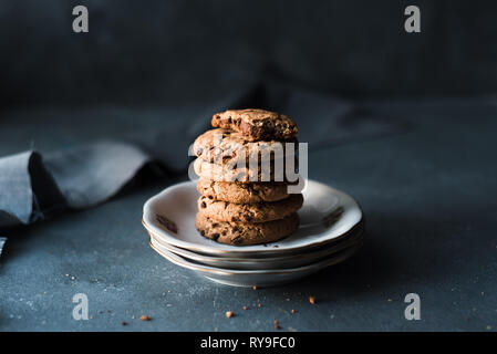 Chocolate Chip Cookies auf dunklem Hintergrund mit Lichthof und kopieren Raum Stockfoto