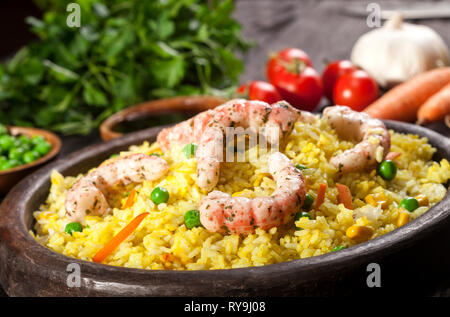 Weißer Reis mit Krabben gekocht, Curry und Gemüse in einer Schüssel auf einem schwarzen Hintergrund. Stockfoto