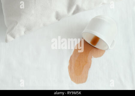 Eine weiße Tasse Kaffee auf das Bett verschüttet. Blick von oben. Close-up. Stockfoto