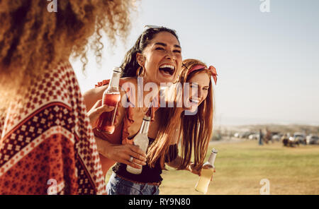 Drei junge Frauen wandern im Freien zusammen und Lachen. Gruppe von multi-ethnischen weibliche Freunde Spaß im Freien. Stockfoto