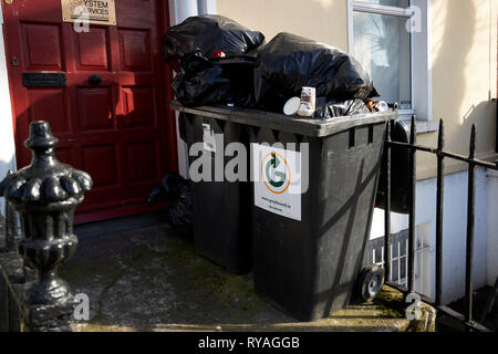 Überquellenden private Unternehmen wheelie Bins außerhalb eines Georgianischen Haus in Büros Dublin Irland Europa. Stockfoto