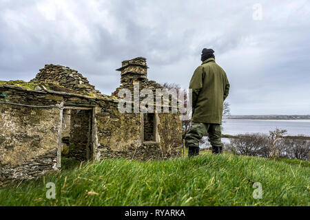 Ardara, County Donegal, Irland. 13. März 2019. Ein Bauer sieht in seinem Lande durch die Ruinen der alten Bauernhaus. Michael Creed, der irische Minister für Landwirtschaft hat heute gesagt, dass die Entscheidung des Vereinigten Königreichs hohe Zölle auf Rindfleisch und Cheddar in einer no-deal Szenario zu verhängen sind "möglicherweise eine Katastrophe" für die irischen Landwirte. Credit: Richard Wayman/Alamy leben Nachrichten Stockfoto