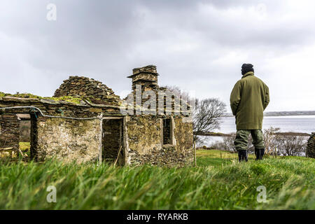 Ardara, County Donegal, Irland. 13. März 2019. Ein Bauer sieht in seinem Lande durch die Ruinen der alten Bauernhaus. Michael Creed, der irische Minister für Landwirtschaft hat heute gesagt, dass die Entscheidung des Vereinigten Königreichs hohe Zölle auf Rindfleisch und Cheddar in einer no-deal Szenario zu verhängen sind "möglicherweise eine Katastrophe" für die irischen Landwirte. Credit: Richard Wayman/Alamy leben Nachrichten Stockfoto