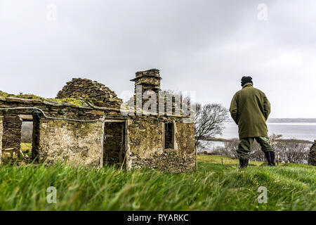 Ardara, County Donegal, Irland. 13. März 2019. Ein Bauer sieht in seinem Lande durch die Ruinen der alten Bauernhaus. Michael Creed, der irische Minister für Landwirtschaft hat heute gesagt, dass die Entscheidung des Vereinigten Königreichs hohe Zölle auf Rindfleisch und Cheddar in einer no-deal Szenario zu verhängen sind "möglicherweise eine Katastrophe" für die irischen Landwirte. Credit: Richard Wayman/Alamy leben Nachrichten Stockfoto