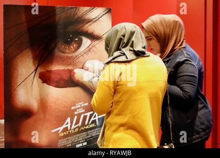 Bagdad. 21 Feb, 2019. Foto am 13.02.21, 2019 zeigt zwei irakische Frauen neben einem Film Plakat an einem Filmtheater in Bagdad, Irak. Um mit der Funktion: Moderne multi-Theater locken avid Irakischen kinobesuchern als ikonenhafte Kinos verblassen Credit: Khalil Dawood/Xinhua/Alamy leben Nachrichten Stockfoto