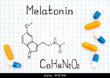 Die chemische Formel von Melatonin mit einigen Pillen. Close-up. Stockfoto