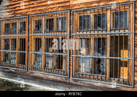 Zerbrochene Fenster mit Metallgitter Stockfoto