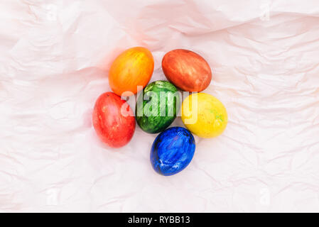 Ostern Komposition mit natürlichen Eier auf einem weißen Hintergrund. Auf zerknittertes Papier sind bunte Eier. Osterferien Stockfoto