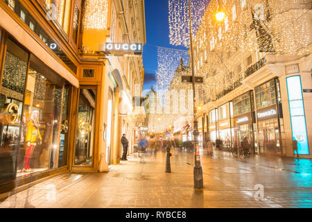 Luxushotels Kohlmarkt mit Hofburg nach hinten, in der Wiener Innenstadt nach Einbruch der Dunkelheit, Österreich. Stockfoto