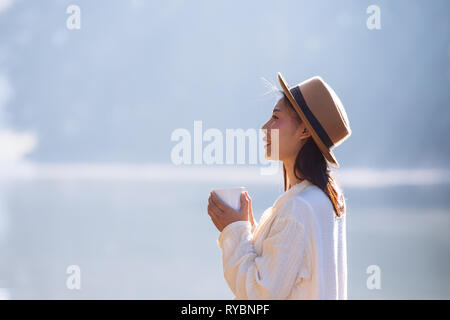 Weibliche Touristen trinken Kaffee am Morgen auf dem Fluss. Stockfoto