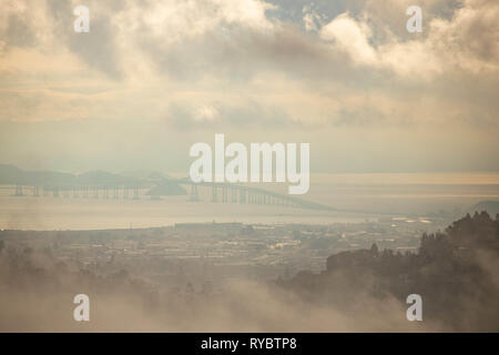 Richmond - San Rafael Bridge durch Nebel und Wolken bei Sonnenuntergang sichtbar Stockfoto