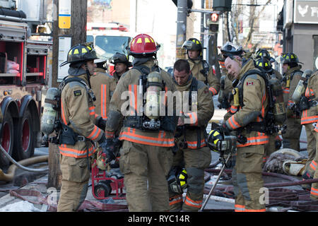 Feuerwehrleute, die im Einsatz eines Gebäudes Feuer in der Stadt. Feuerwehrleute Brandbekämpfung. Stockfoto