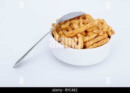 Portrait von Masala kurkure mit Löffel in der Schüssel. Auf den weißen Hintergrund isoliert. Stockfoto