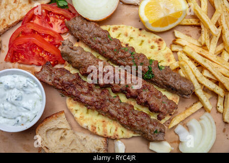 Kebab, traditionelle türkische, griechische Fleisch essen auf Fladenbrot, Zaziki Soße und Kartoffeln, Ansicht von oben Stockfoto