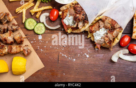 Gyros Pita, Shawarma, Souvlaki. Traditionelle türkische, griechische Speisen. Zwei pita Brot wraps und Fleischspieße auf Holztisch, Kopieren, Ansicht von oben Stockfoto